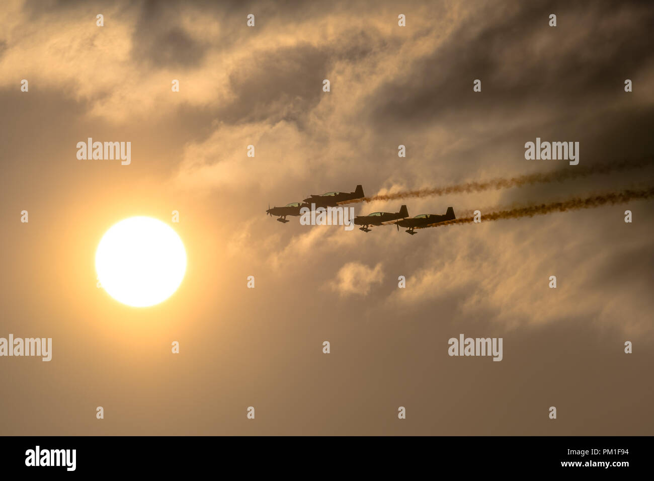 SOUTHPORT, UK JULY 6 2018:  A photograph documenting The Blades Aerobatic Display Team performing at dusk, flying across the setting sun, at the annua Stock Photo