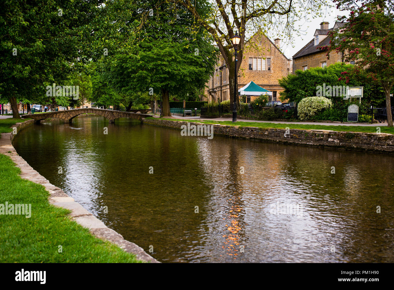 Burton-on-the-Water is a Conservation Area of the Cotswolds with low stone  arched footbriges and honey-colored stone houses on the River Windrush  Stock Photo - Alamy