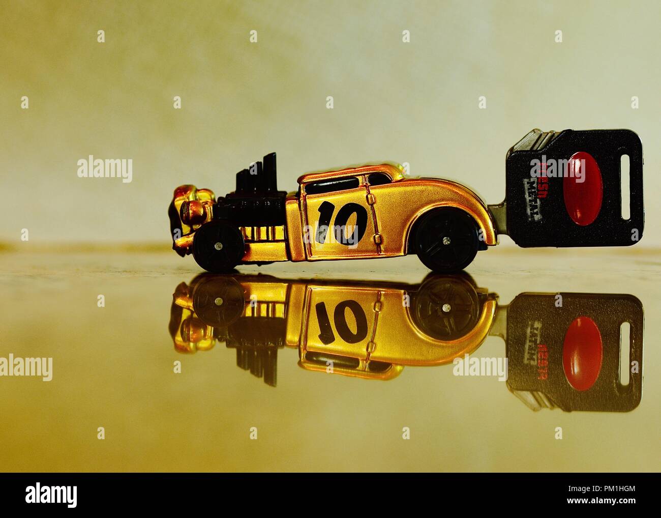 gold spring loaded toy car reflection Stock Photo