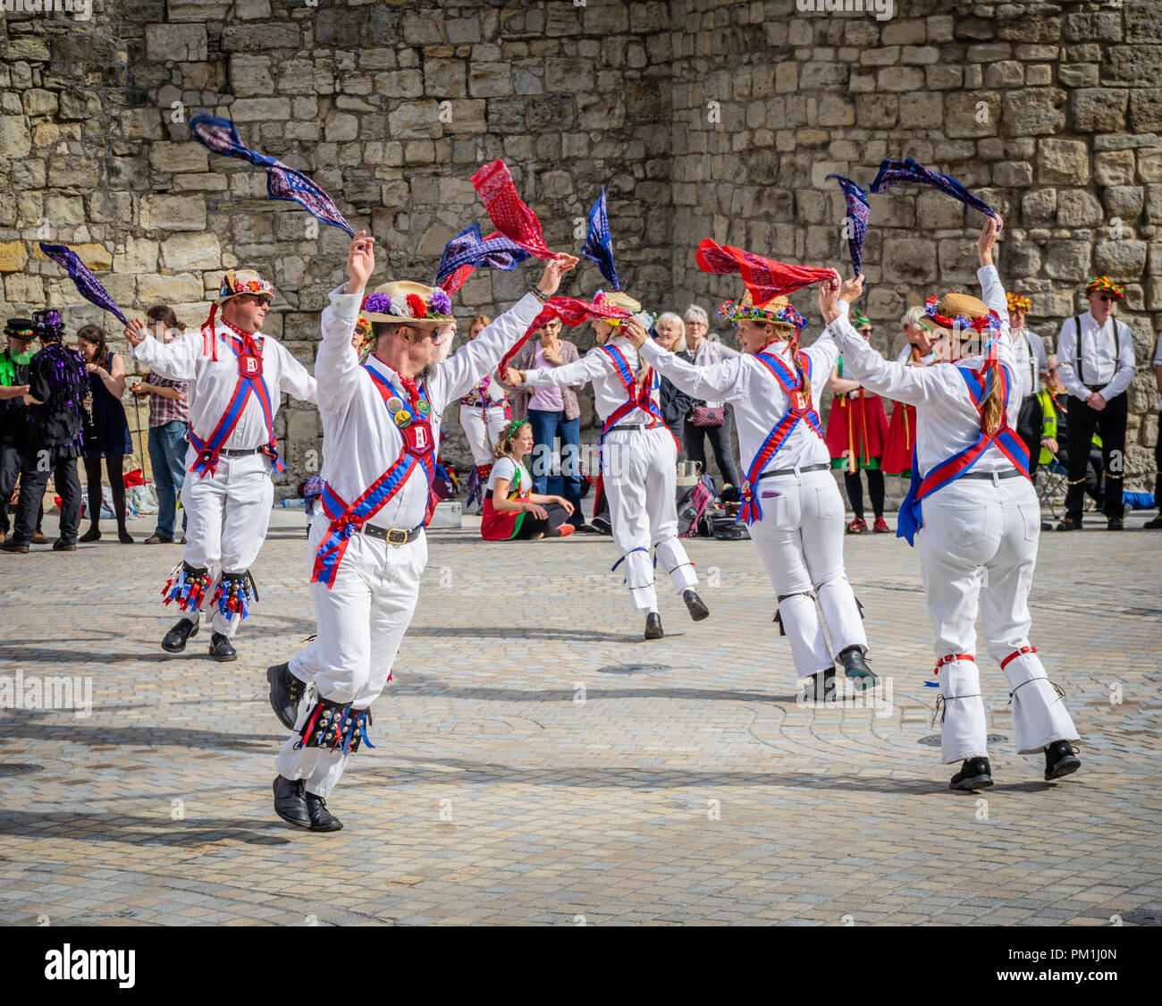 A group of female and male Morris dancers perform a Morris dance in front of the historic Southampton Walls, Southampton, Hampshire, England, UK Stock Photo