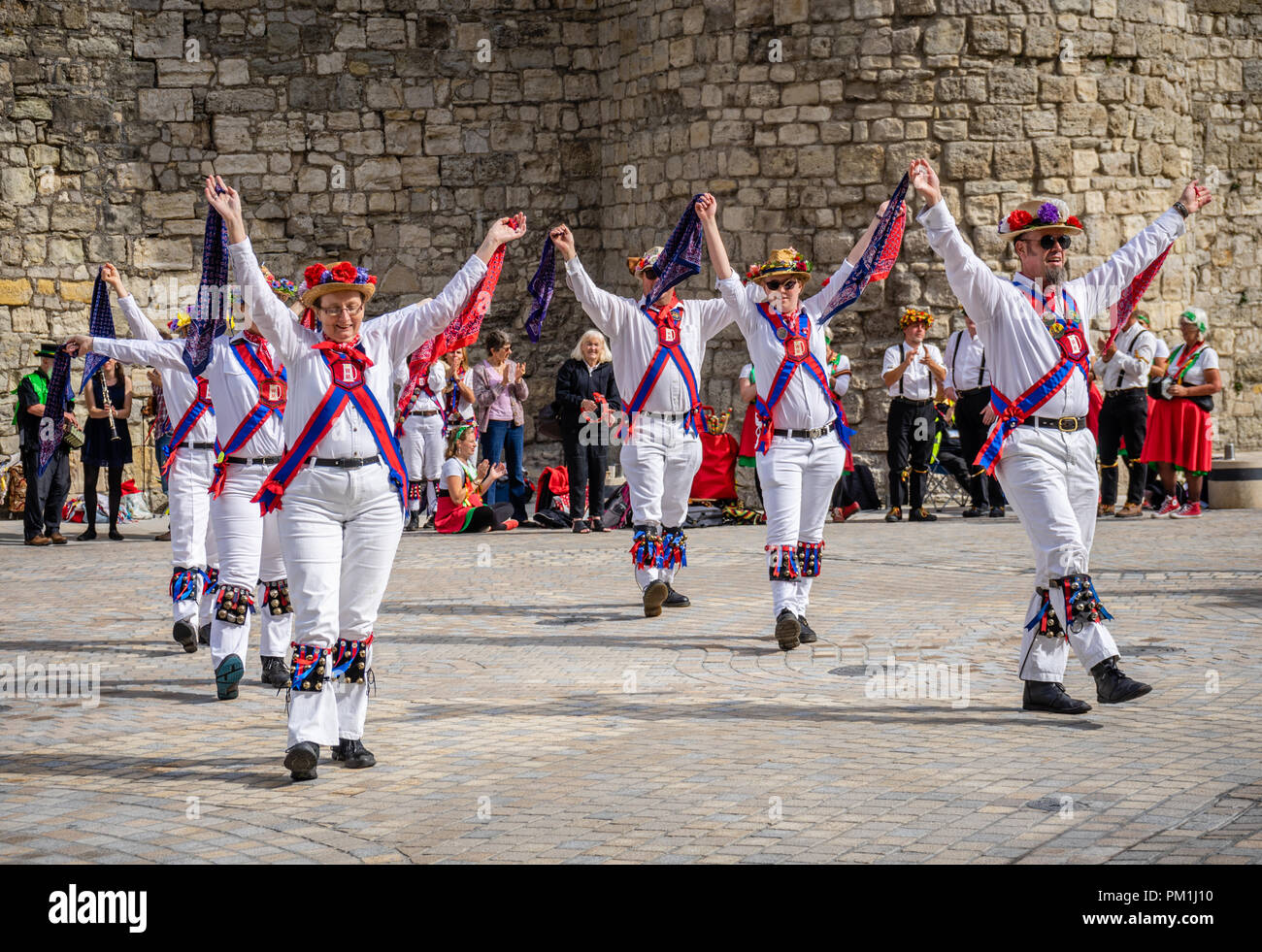 A group of female and male Morris dancers perform a Morris dance in front of the Southampton Walls, Southampton, Hampshire, England, UK Stock Photo