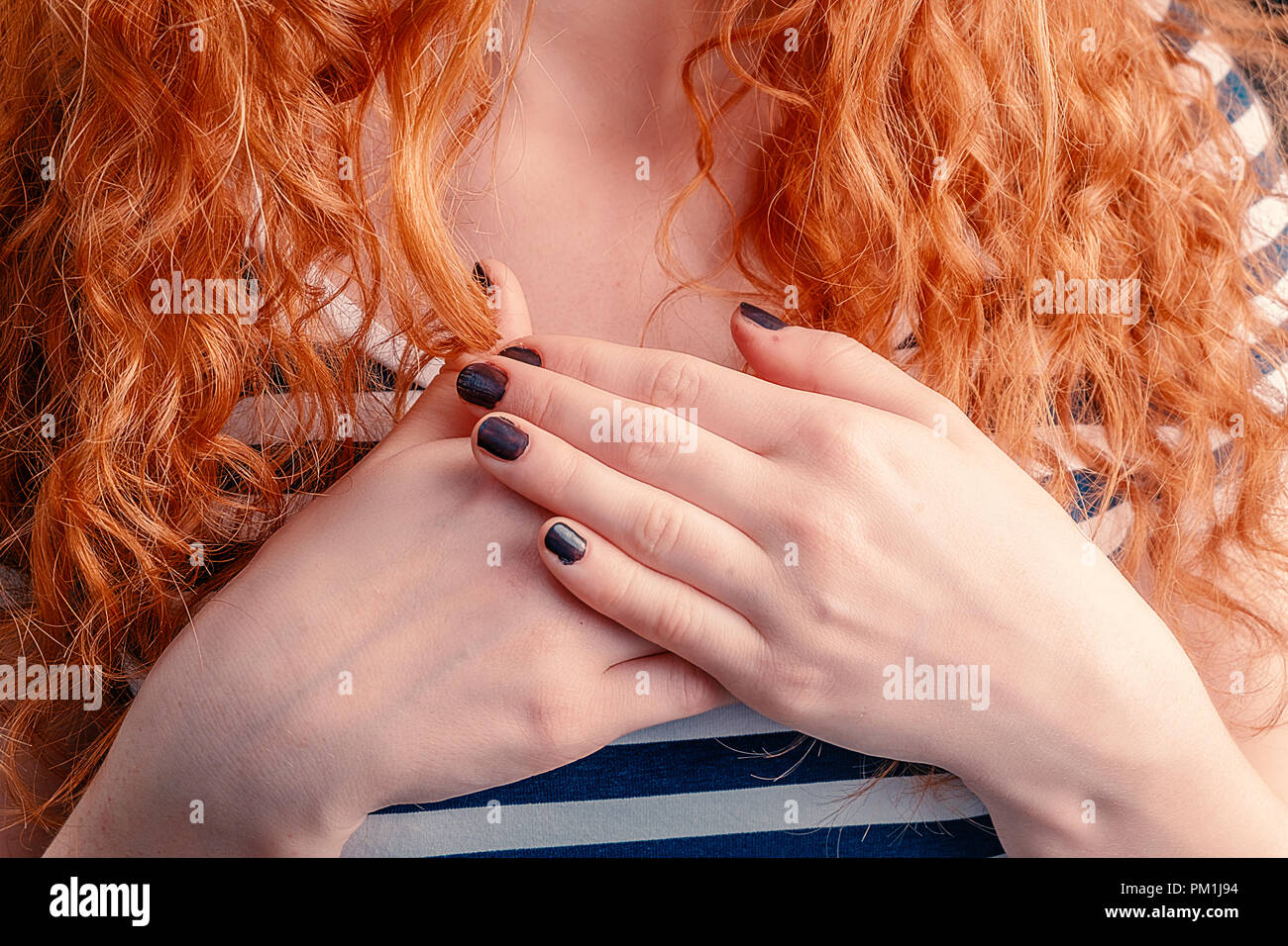 Ginger haired girl chest with her hands connected together in the center, sign of love and acception Stock Photo