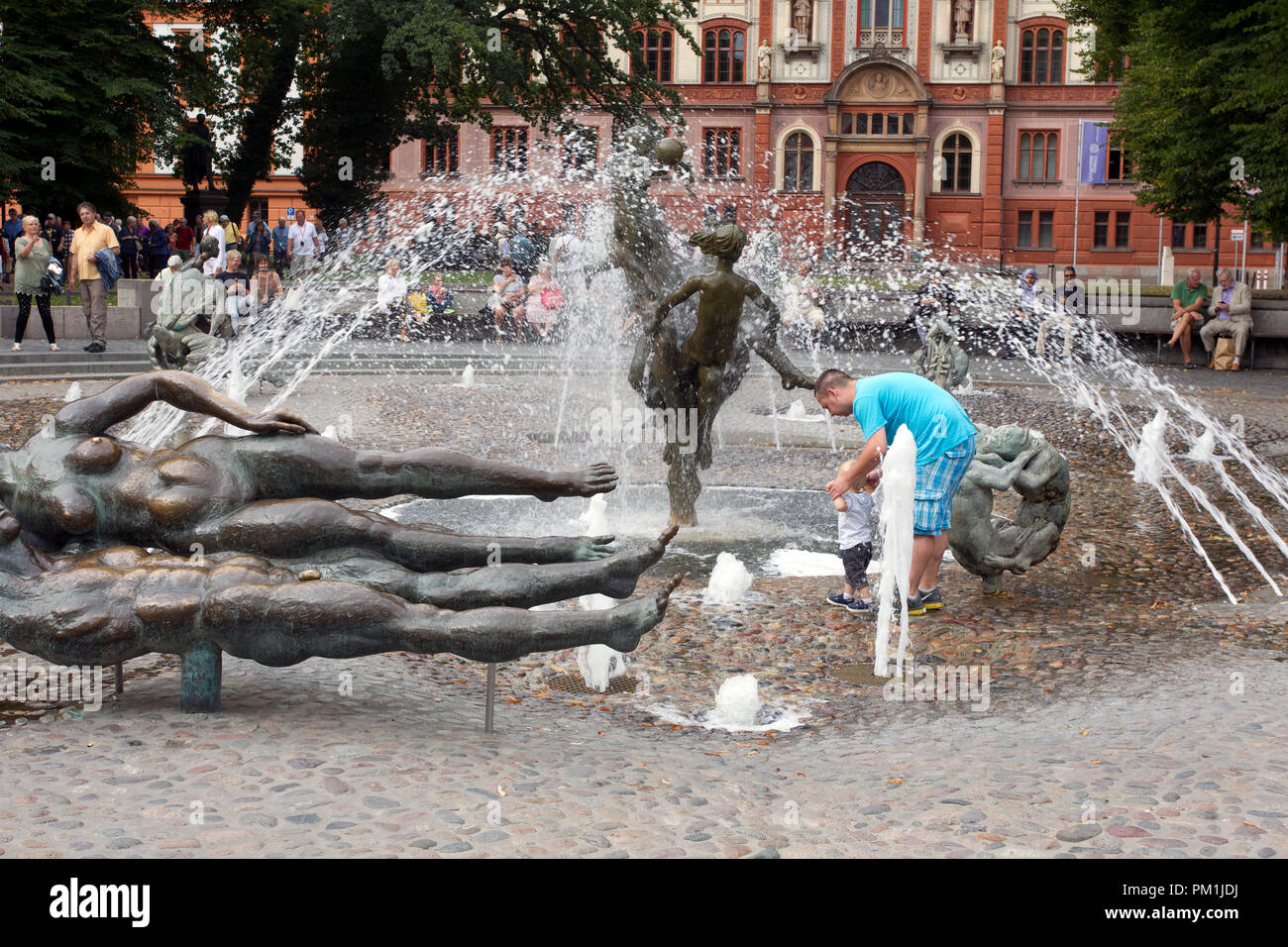 Man holding toddler childs hands in fountain in front of hi-res stock ...