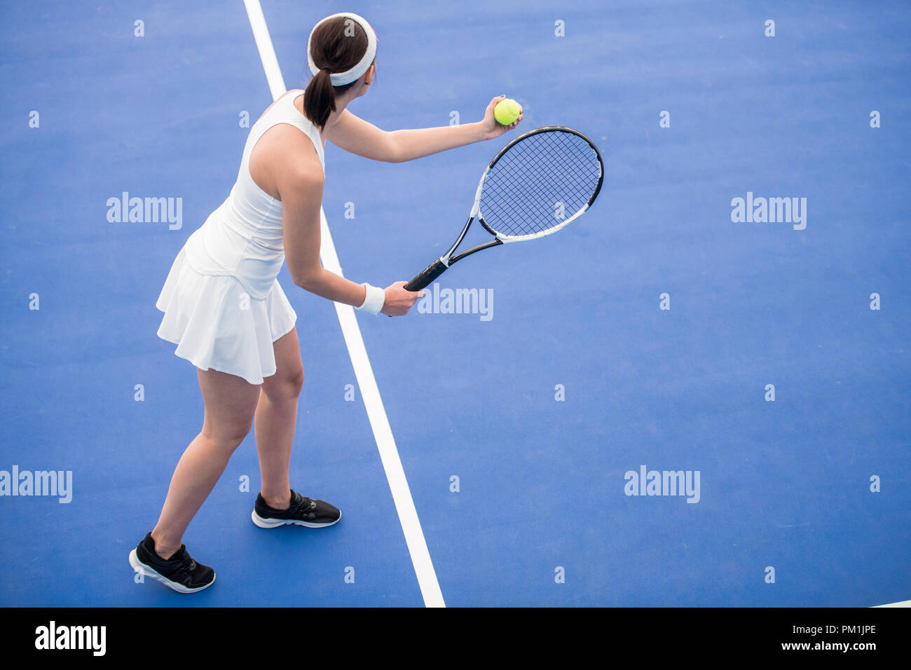 Female Tennis Player Serving Ball Stock Photo
