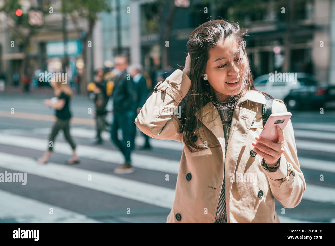 lovely asian woman finding her boyfriend texting her on phone and looking joyfully for replying the messsage. Stock Photo