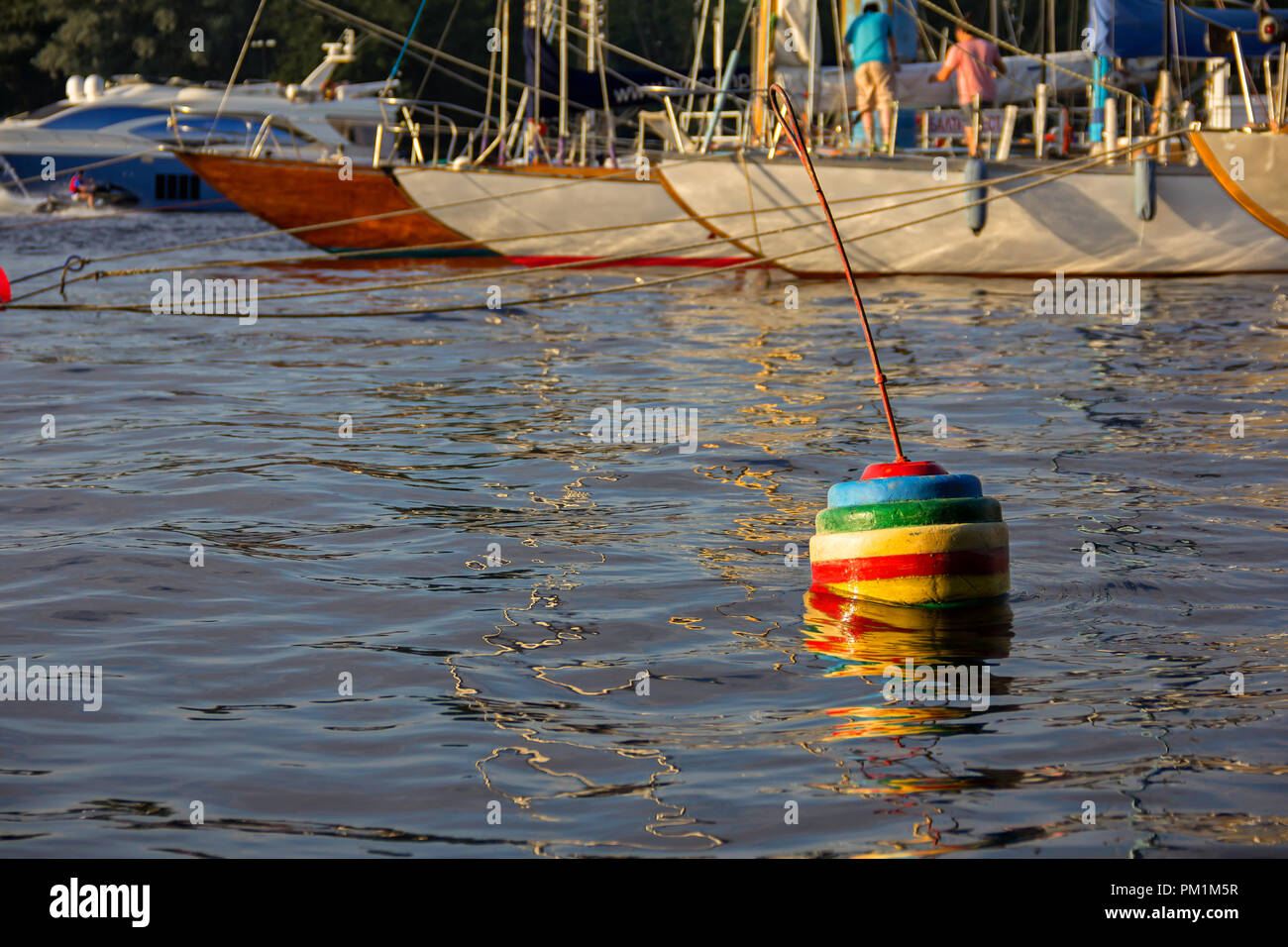 nautical part of a yacht with cords, rigging, sail, mast, anchor, knots on yachts tied up to buoys at a moorage of a yacht club Stock Photo