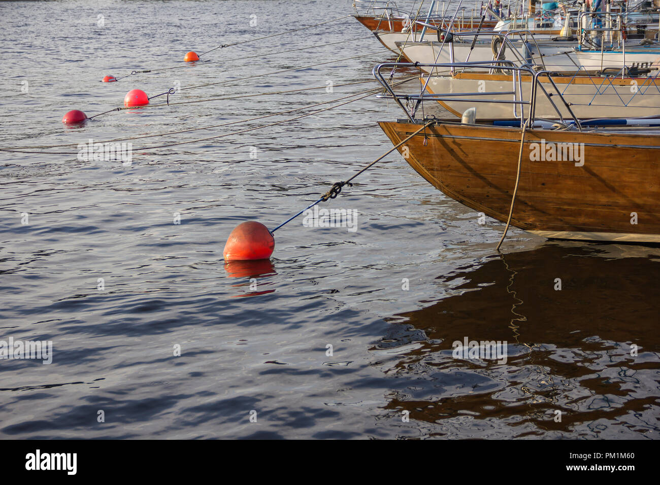 nautical part of a yacht with cords, rigging, sail, mast, anchor, knots on yachts tied up to buoys at a moorage of a yacht club Stock Photo