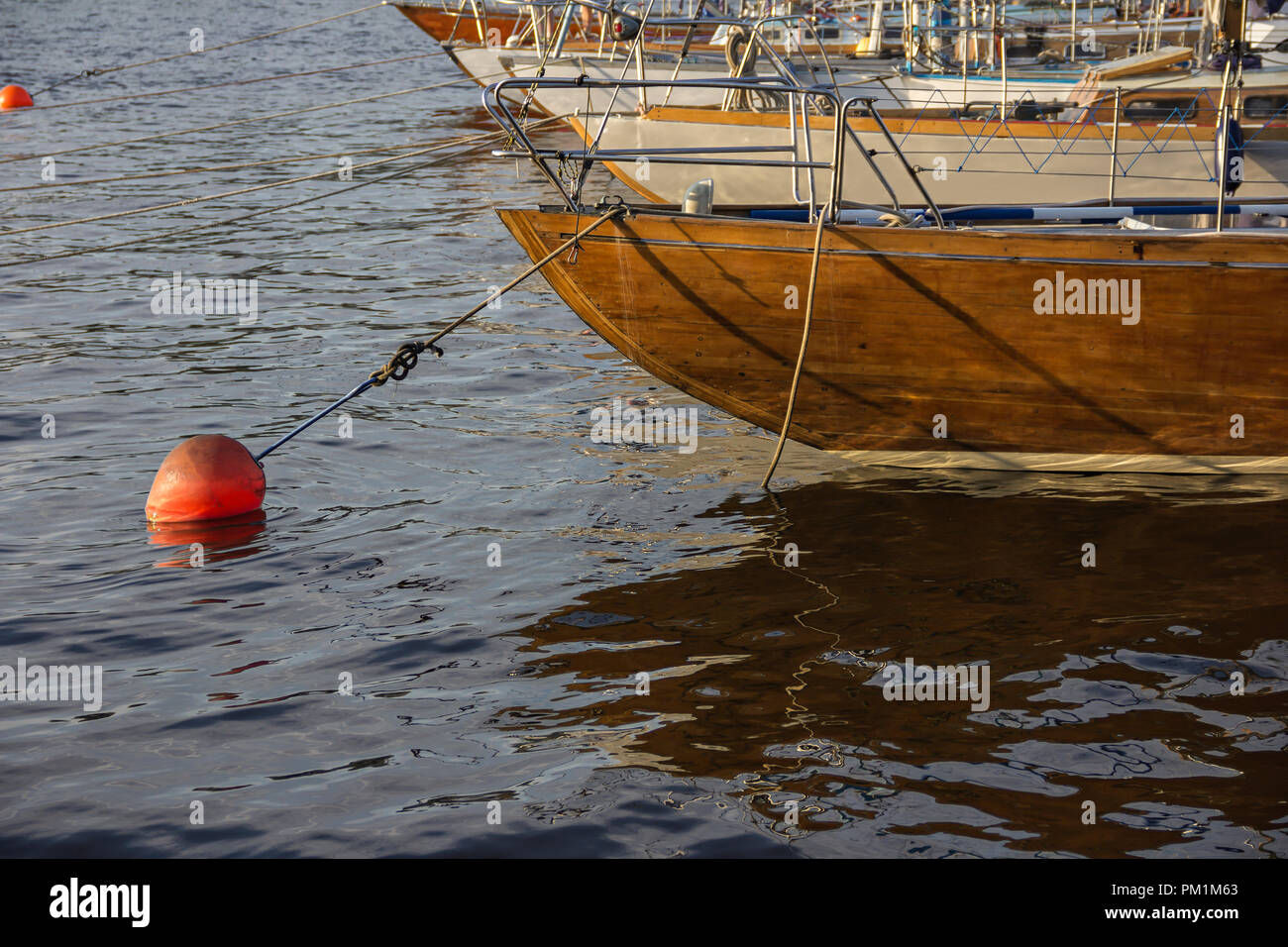 nautical part of a yacht with cords, rigging, sail, mast, anchor, knots on yachts tied up to buoys at a moorage of a yacht club Stock Photo