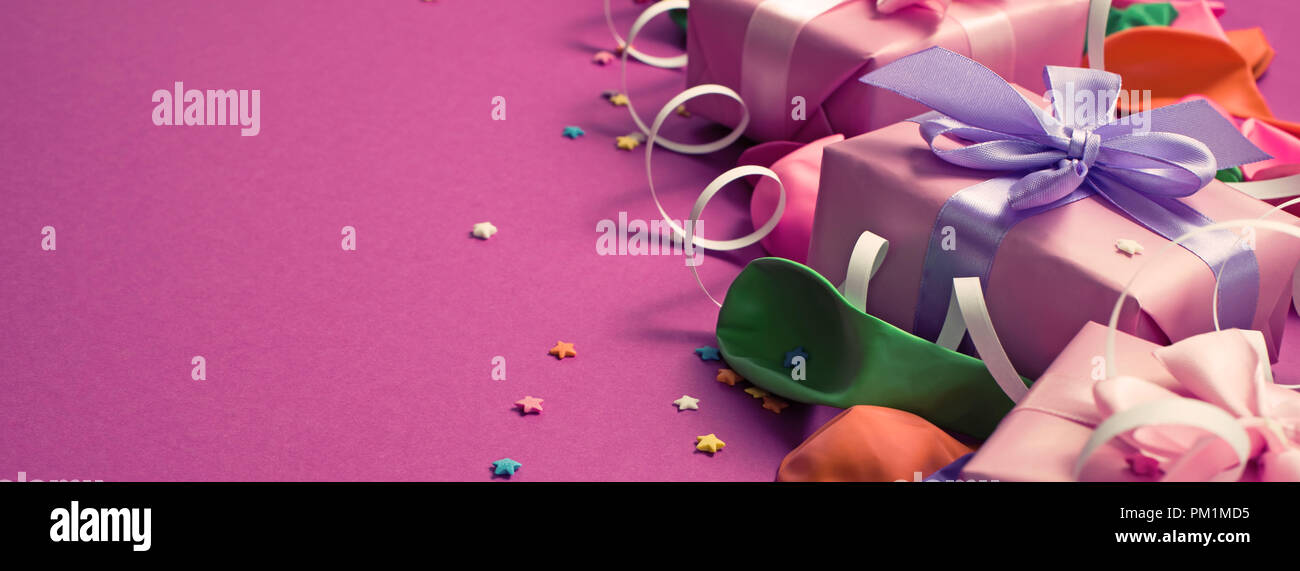 Banner Festive background of purple material colorful balloons streamers confetti. Top view flat lay copy space Stock Photo