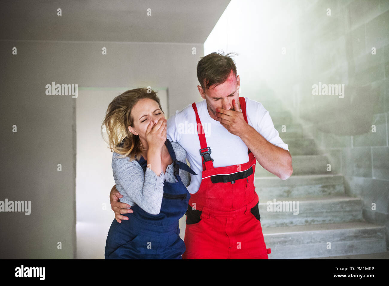 Woman and man workers suffocating at the construction site. Stock Photo