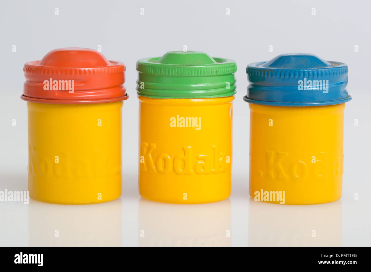 1950s Kodak Kodachrome, Tri-X, and Ektachrome yellow canisters coded by the colors of red, green, and blue screw top lids. Stock Photo