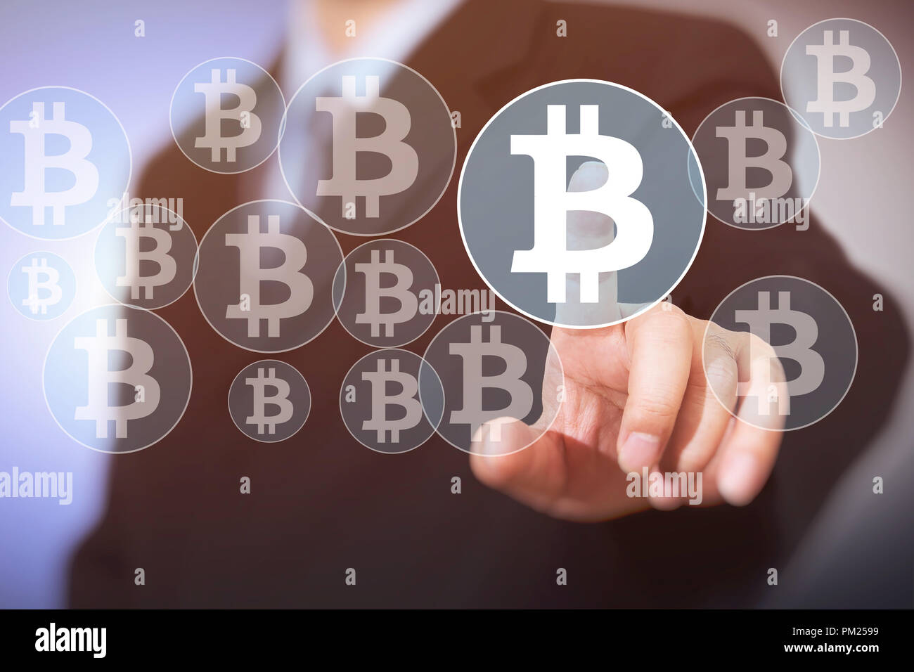 Bitcoin button on virtual interface displaying, businessman touching the currency symbol Stock Photo