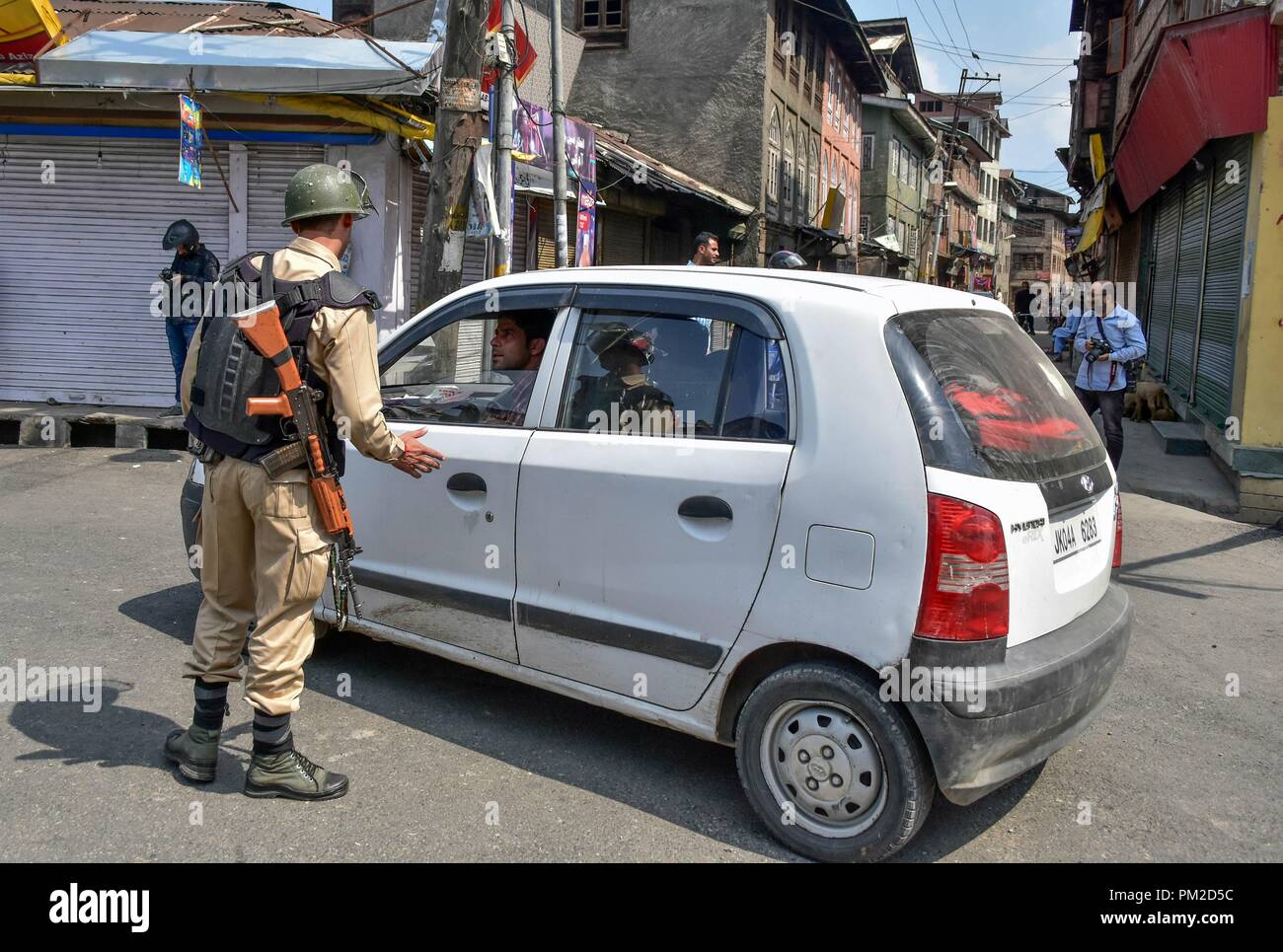 Srinagar, Kashmir. 17th Sep 2018. A paramilitary trooper stops a vehicle during shutdown in Srinagar, Kashmir. A shutdown is being observed in Kashmir on the call of separatist leadership to protest against the killing of a civilian and five militants during encounter with government forces in south Kashmir. Shops, schools and colleges were shut following a call by separatists, while authorities imposed curfew in several areas to stop street protests. Credit: Saqib Majeed/SOPA Images/ZUMA Wire/Alamy Live News Stock Photo