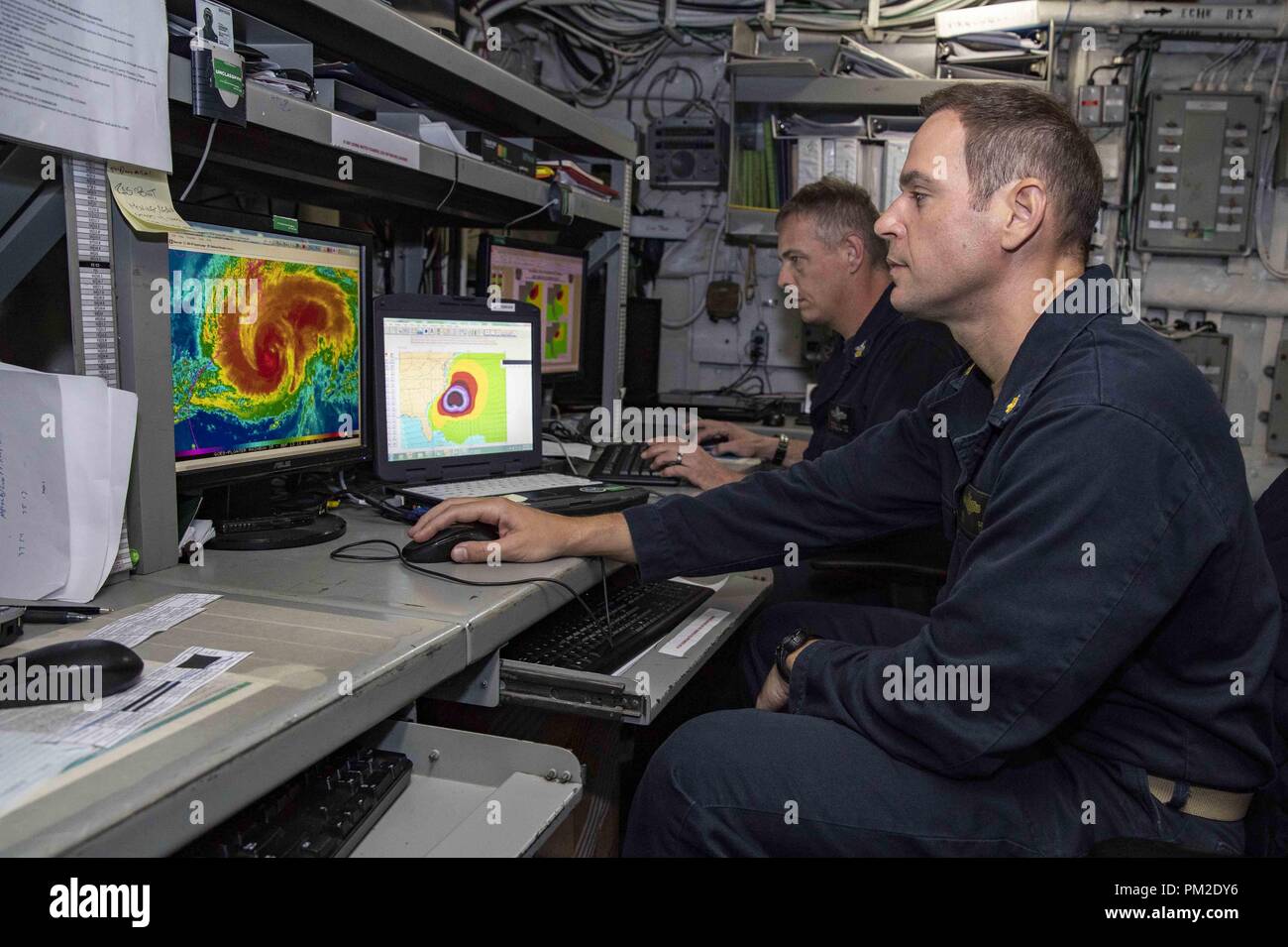 Atlantic Ocean. 13th Sep, 2018. ATLANTIC OCEAN (Sept. 13, 2018) Lt. Cmdr. Chad Geis, right, meteorological and ceanographic officer, and Aerographer's Mate 1st Class Russell Ligon analyze Hurricane Florence in the meteorological room aboard the Wasp-class amphibious assault ship USS Kearsarge (LHD 3). U.S. Naval Forces Northern Command deployed Kearsarge, along with embarked elements of the 22nd Marine Expeditionary Unit and the Expeditionary Strike Group 2 command element, to be positioned to provide Defense Support to Civil Authorities from the sea in response to Hurricane Florence, sh Stock Photo