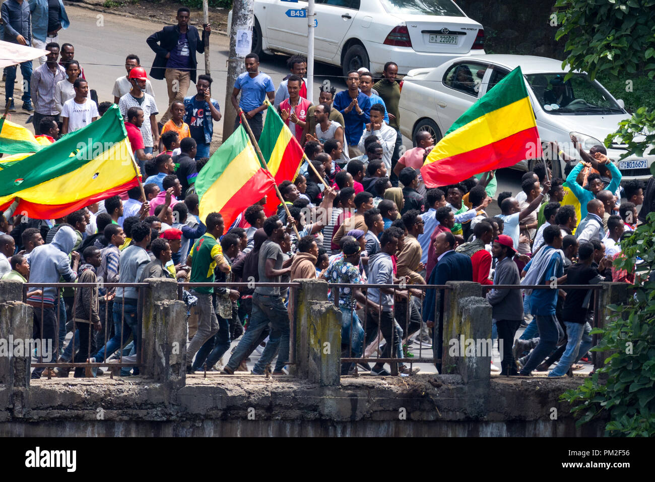 Addis Ababa, Ethiopia . 17th September 2018.  Residents of Addis Ababa run with a version of the green, yellow, and red Ethiopian flag (without emblem) across the Ras Mekonnen bridge in Piassa. They are part of a large crowd of the city's residents protesting the recent violence in the city prior to and during the return of members of the Oromo Liberation Front (OLF/ONEG) to Ethiopia this weekend (September 13-16 2018) Credit: David Kirba/Alamy Live News Stock Photo