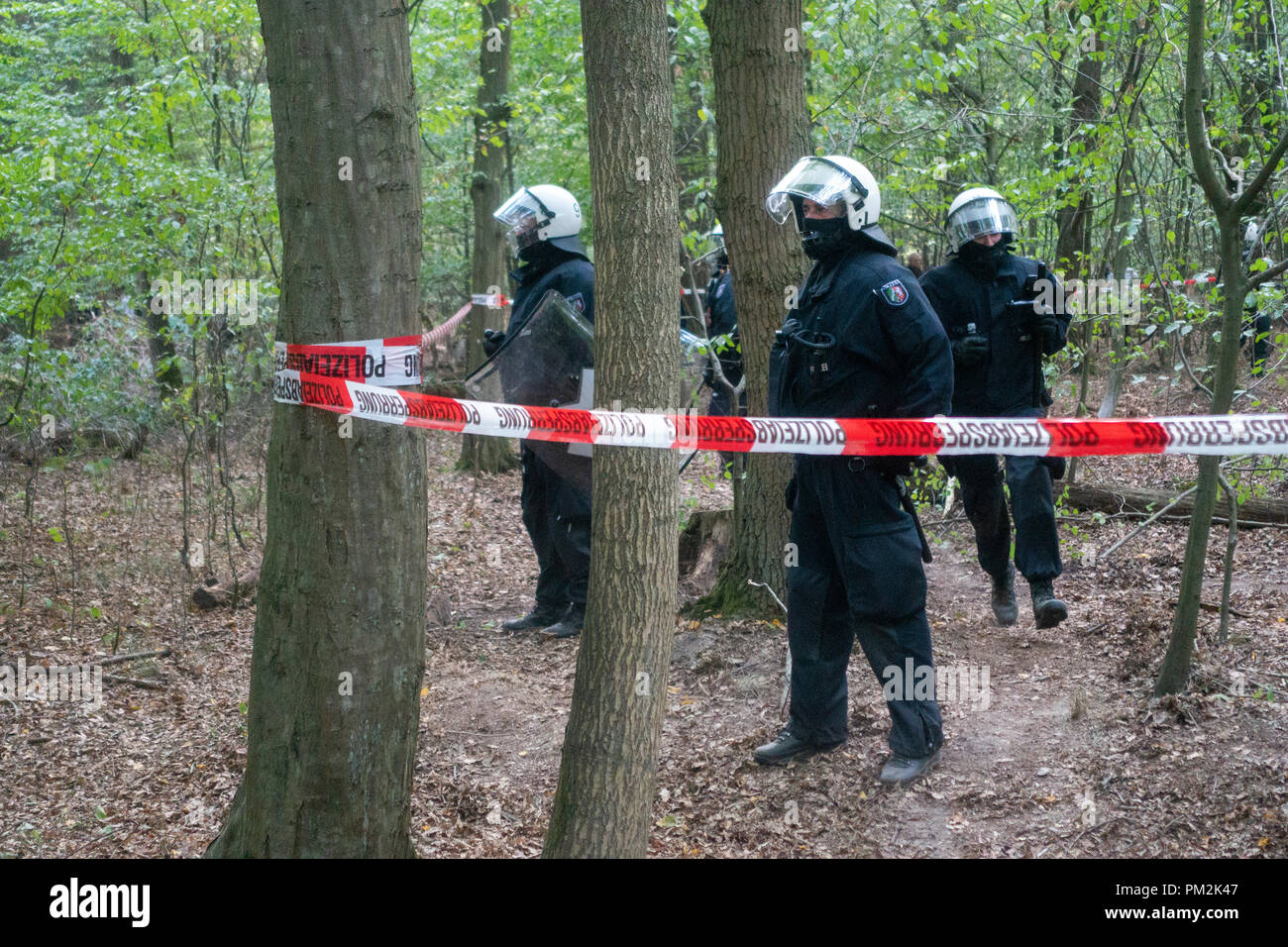 16 September 2018, North Rhine-Westphalia, Kerpen: Police officers standing behind a barricade at Hambach Forest. For the fourth day in a row, emergency forces continued the evacuation of the activists' tree houses. Photo: Arnulf Stoffel/dpa Stock Photo