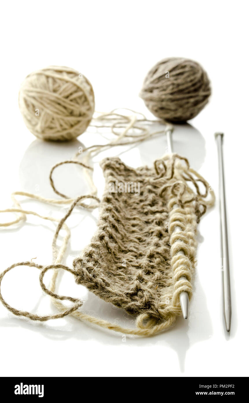 Pattern of knitting with grey ball of woollen thread and needles ...