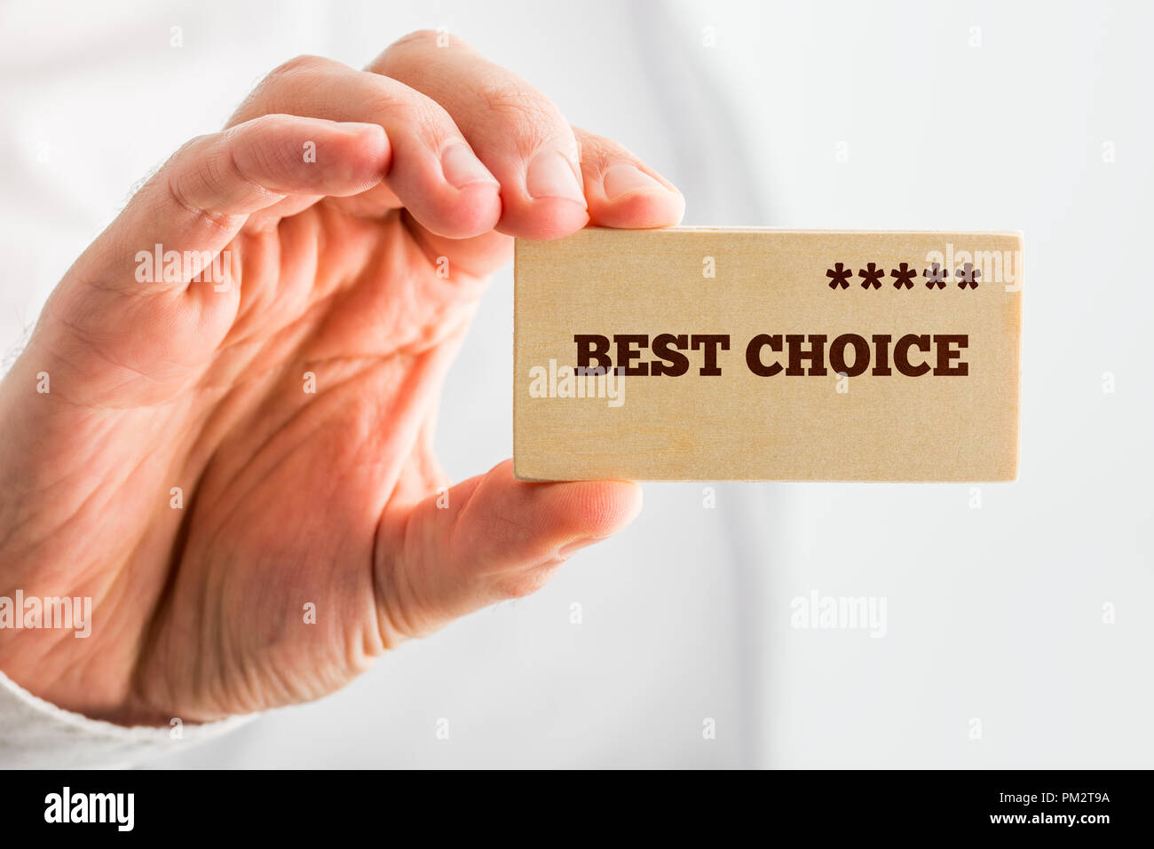 Man holding a wooden rectangle saying Best Choice with a line of five stars depicting good value, 5-star quality and popularity ranking. Stock Photo