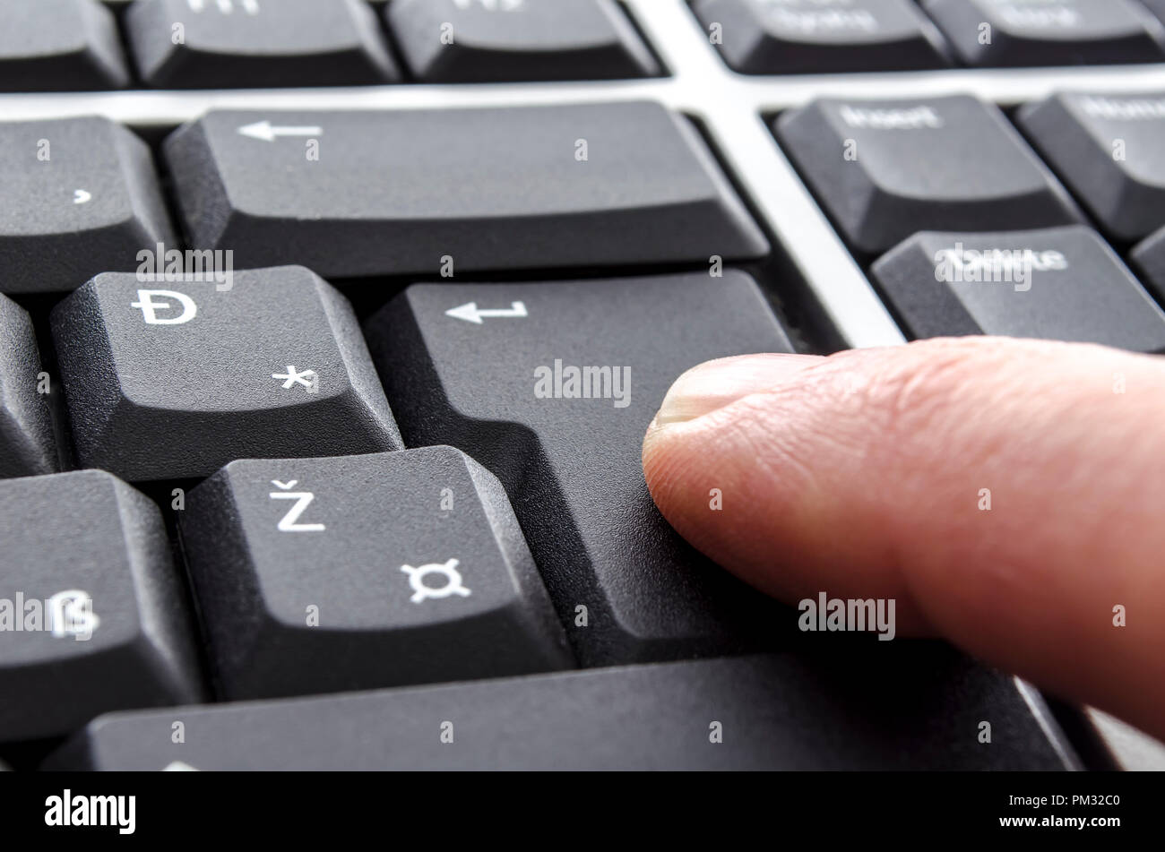 Closeup of a finger pushing enter button. Stock Photo