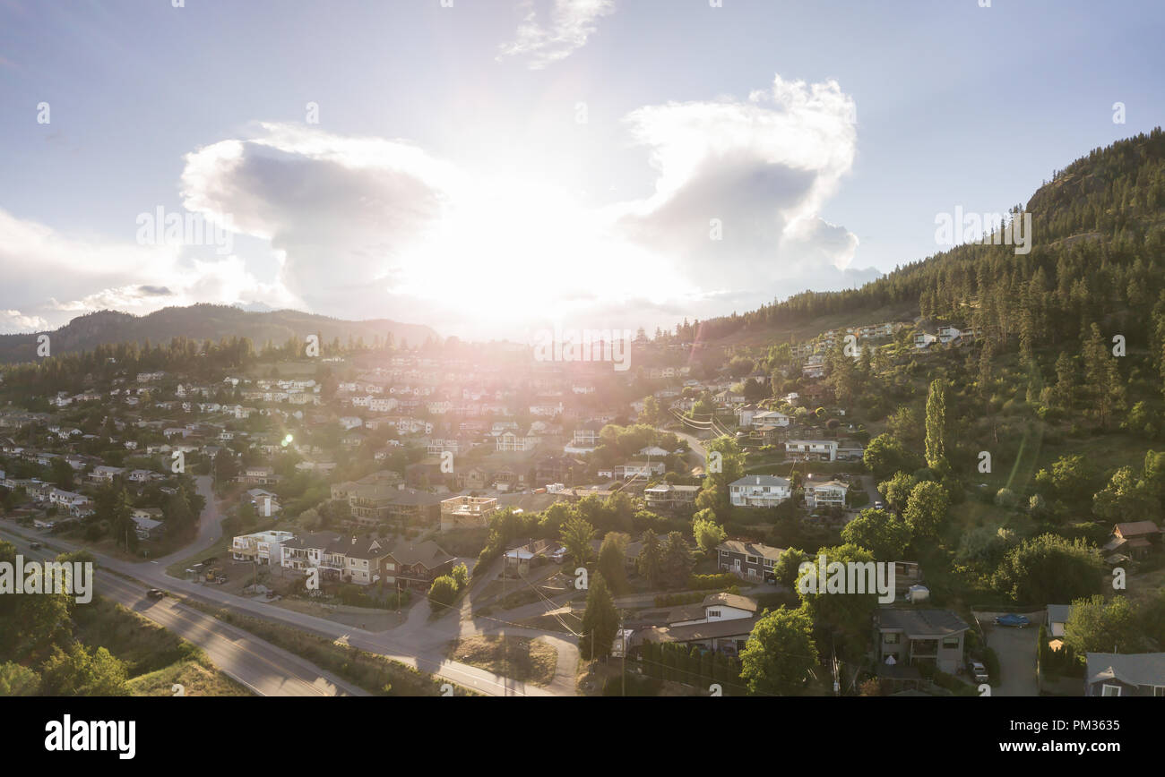 Aerial panoramic view of a small town on the hill near Okanagan Lake during a vibrant summer sunset. Taken in Peachland, BC, Canada. Stock Photo
