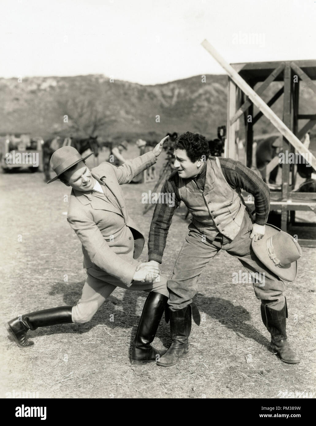 Silent film scene still. Two men in boots and western wear grappling, 1930.  File Reference # 1183 010THA Stock Photo
