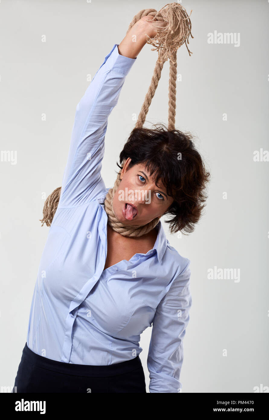 Mature businesswoman mimicking hanging herself out of stress Stock Photo
