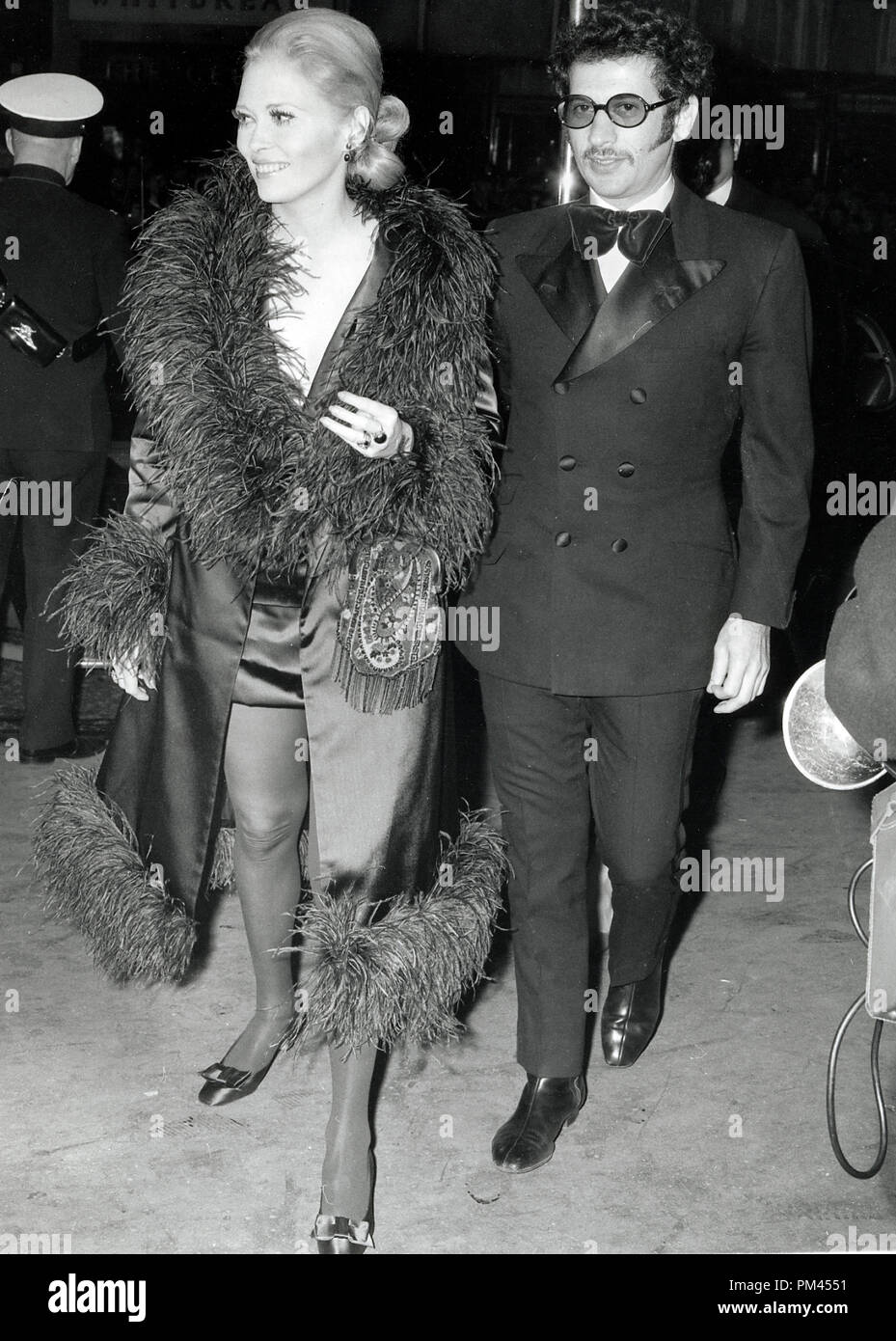 Faye Dunaway wearing a mini skirt and feather-trimmed coat and Jerry Schatzberg at the Movie Premiere of 'Camelot' November1967. File Reference #1031 003THA © JRC /The Hollywood Archive - All Rights Reserved. Stock Photo