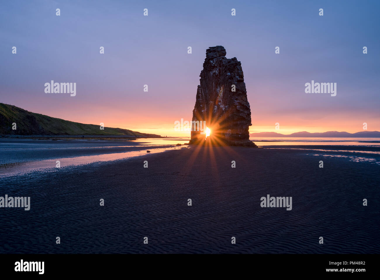 Hvitserkur - basalt stack on the shore of ocean, Vatnsnes peninsula, Iceland. Tourist attraction. Rays of the Rising Sun Stock Photo