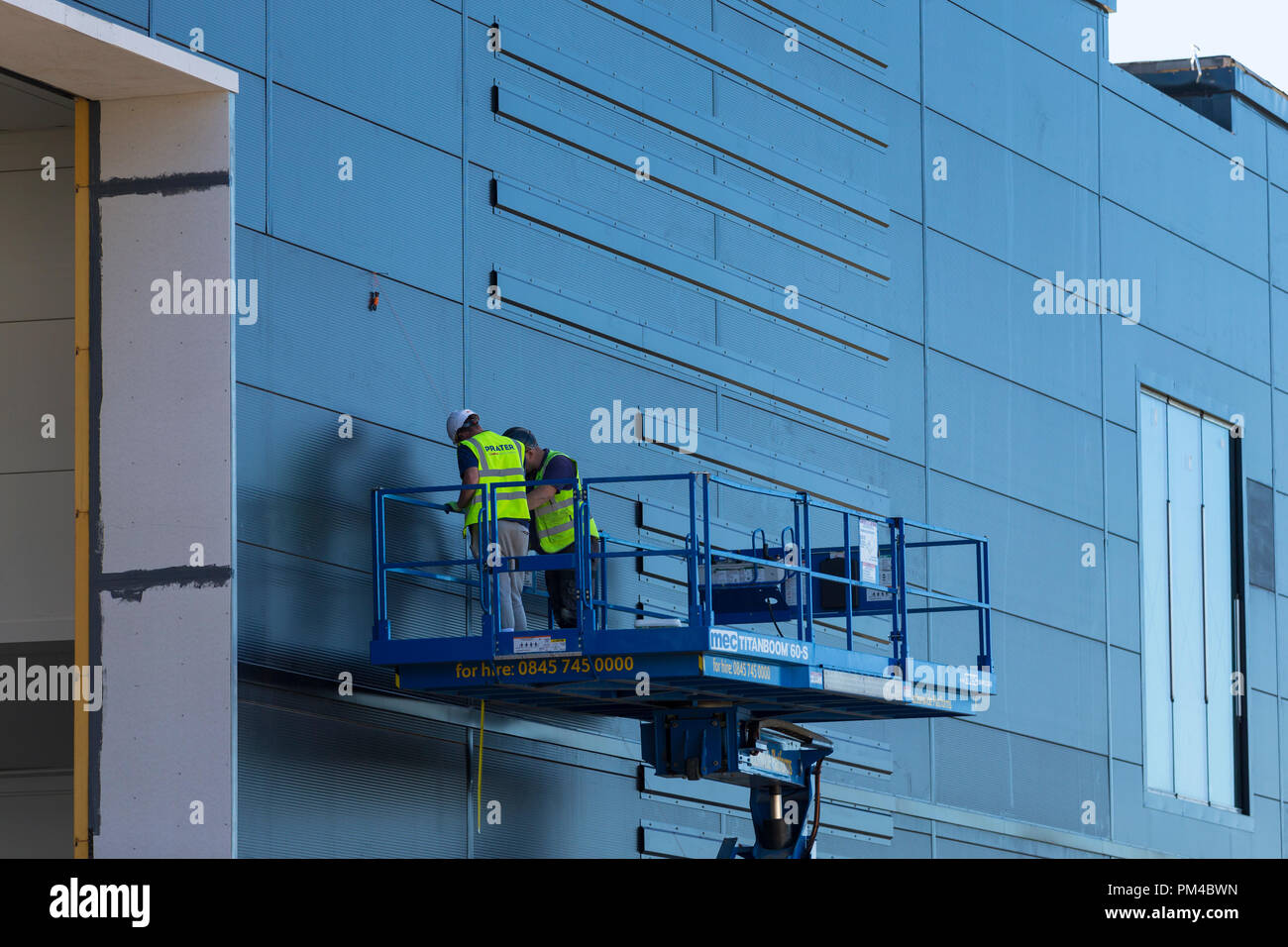 workmen working on a raised platform with protective clothing, uk Stock Photo