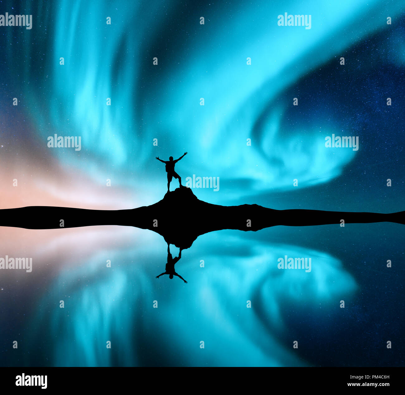 Northern lights and silhouette of standing man with raised up arms on ...