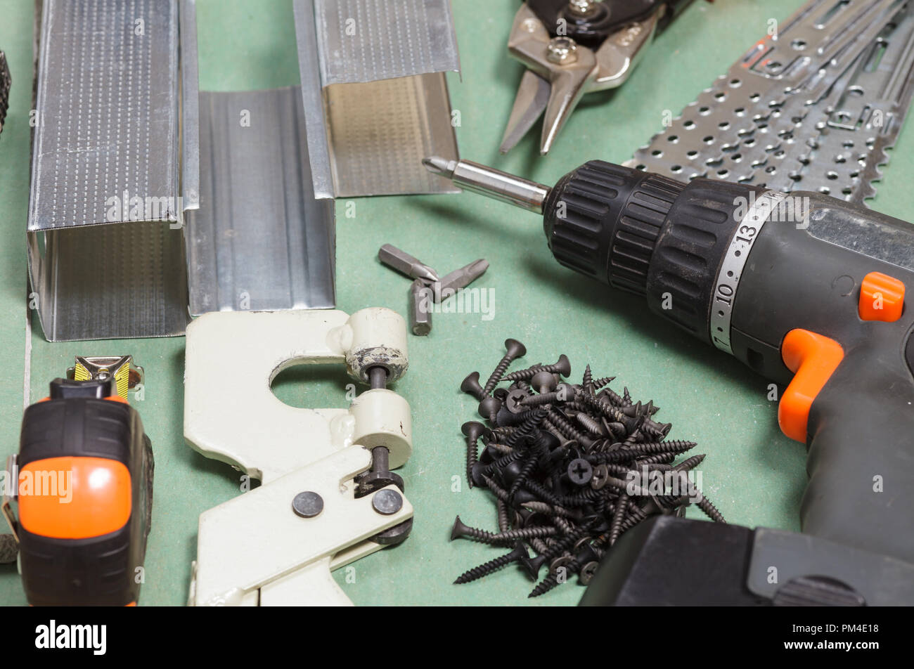 Plasterboard tools set with metal studs, screws, tape measure, screwgun