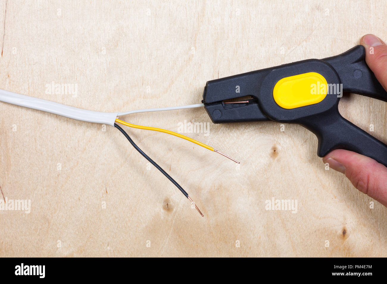 Person uses an automatic wire stripper to strip the electrical