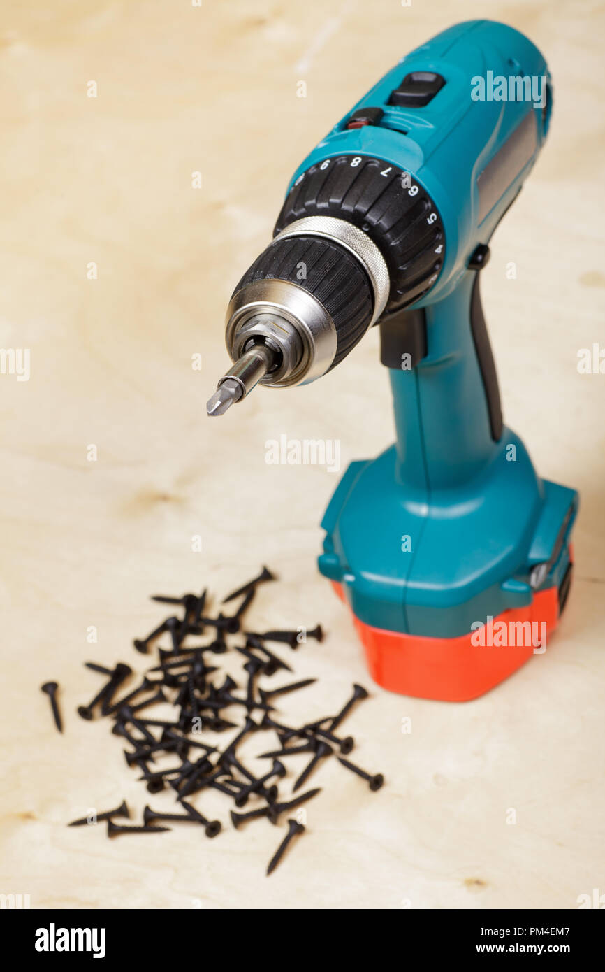 Cordless drill with screws on background Stock Photo Alamy