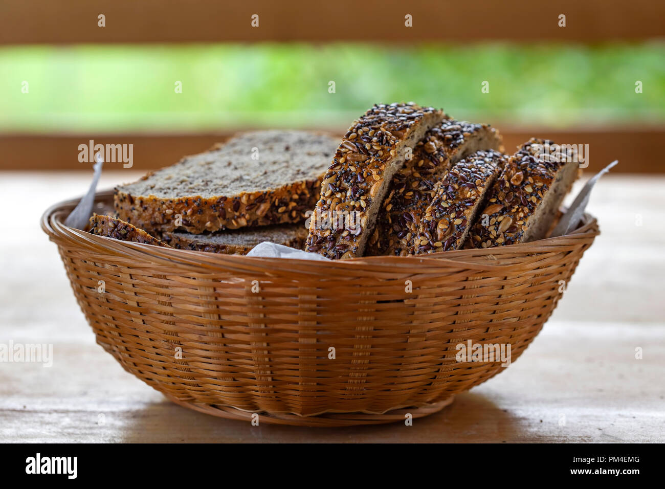 Basket with slices of bread with seeds on the table in summer season Stock Photo
