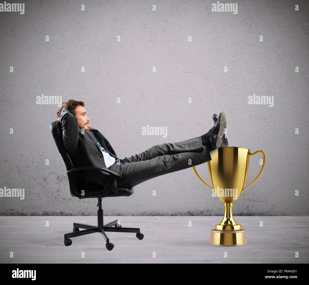 Winner businessman relaxing over a golden cup Stock Photo
