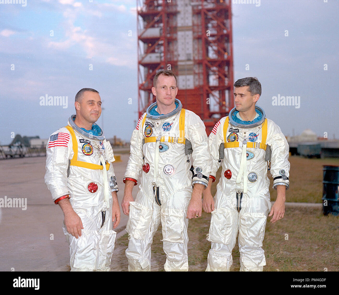 Astronauts (left to right) Gus Grissom, Ed White, and Roger Chaffee, pose in front of Launch Complex 34 which is housing their Saturn 1 launch vehicle. January of 1967. The astronauts later died tragically in a fire on the pad.   File Reference # 1001 001THA Stock Photo