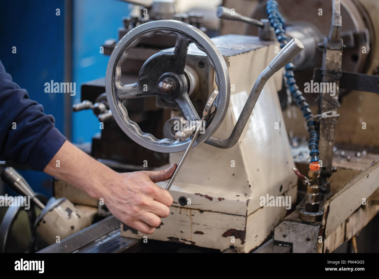 Craftsman turning valve of machine in factory. Stock Photo