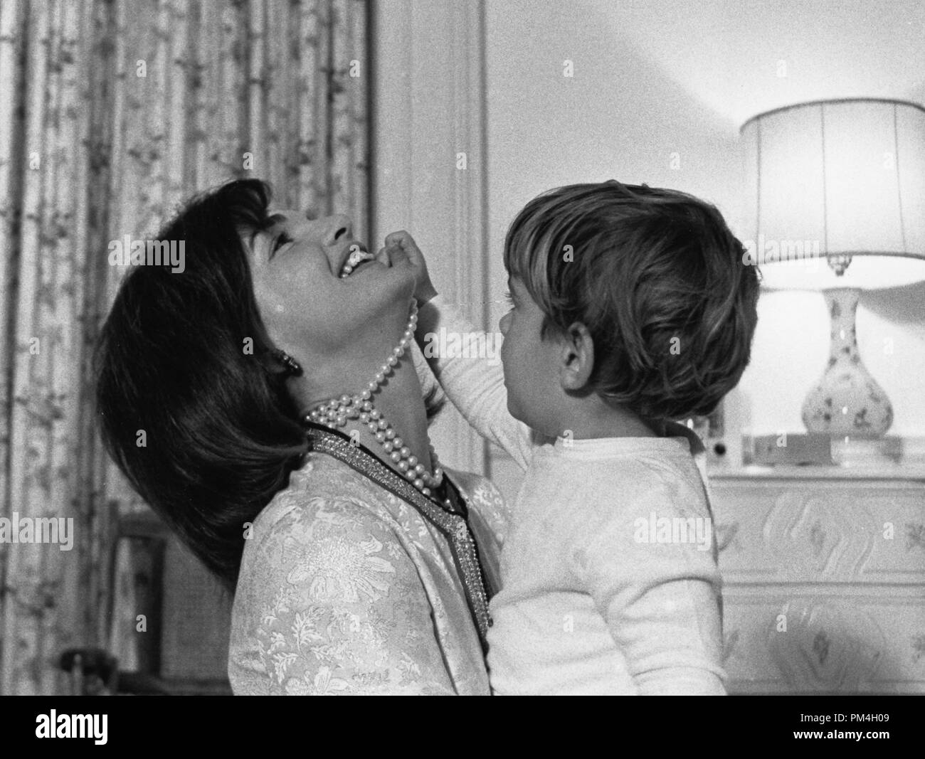 This photograph, part of the John F. Kennedy Presidential Library, taken in First Lady Jacqueline Kennedy as she plays with her son John F. Kennedy Jr., in the west bedroom of the White House, Washington. August 1962  File Reference # 1003 160THA Stock Photo