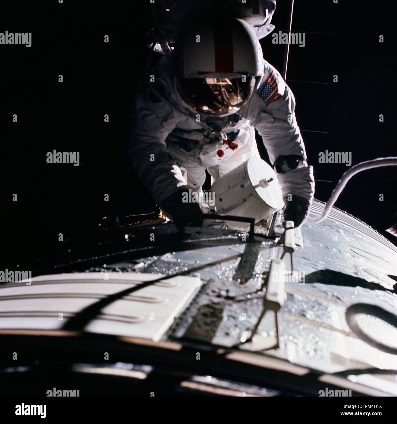 (17 Dec. 1972) --- Astronaut Ronald E. Evans is photographed performing extravehicular activity during the Apollo 17 spacecraft's trans-Earth coast. During his EVA, command module pilot Evans retrieved film cassettes from the Lunar Sounder, Mapping Camera, and Panoramic Camera. The cylindrical object at Evans' left side is the Mapping Camera cassette. The total time for the trans-Earth EVA was one hour seven minutes 18 seconds, starting at ground elapsed time of 257:25 (2:28 p.m.) and ending at ground elapsed timed of 258:42 (3:35 p.m.) on Sunday, Dec. 17, 1972.  File Reference # 1003 182THA Stock Photo