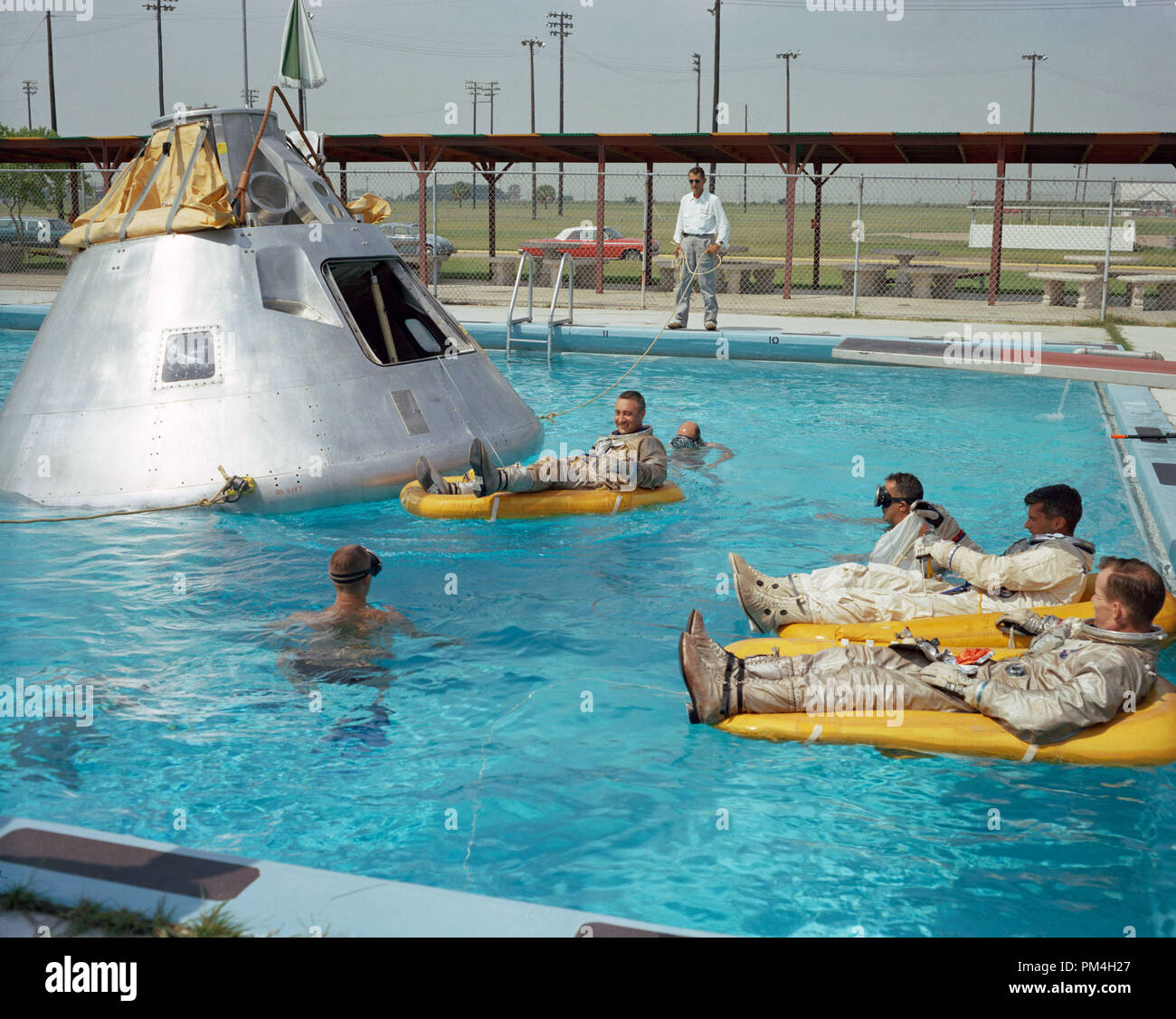 (June 1966) --- Prime crew for the first manned Apollo mission practice water egress procedures with full scale boilerplate model of their spacecraft. In the water at right is astronaut Edward H. White (foreground) and astronaut Roger B. Chaffee. In raft near the spacecraft is astronaut Virgil I. Grissom. NASA swimmers are in the water to assist in the practice session that took place at Ellington AFB, near the Manned Spacecraft Center, Houston.   File Reference # 1003 187THA Stock Photo