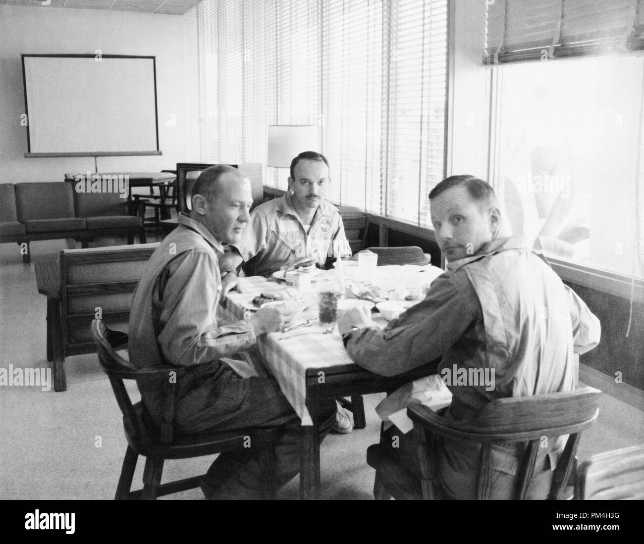 The crew of the Apollo 11 mission is seen dining in the Crew Reception Area of the Lunar Receiving Laboratory after the Apollo 11 mission. Left to right, are Astronauts Buzz Aldrin, Michael Collins, and Neil Armstrong, 1969.  File Reference # 1003 205THA Stock Photo