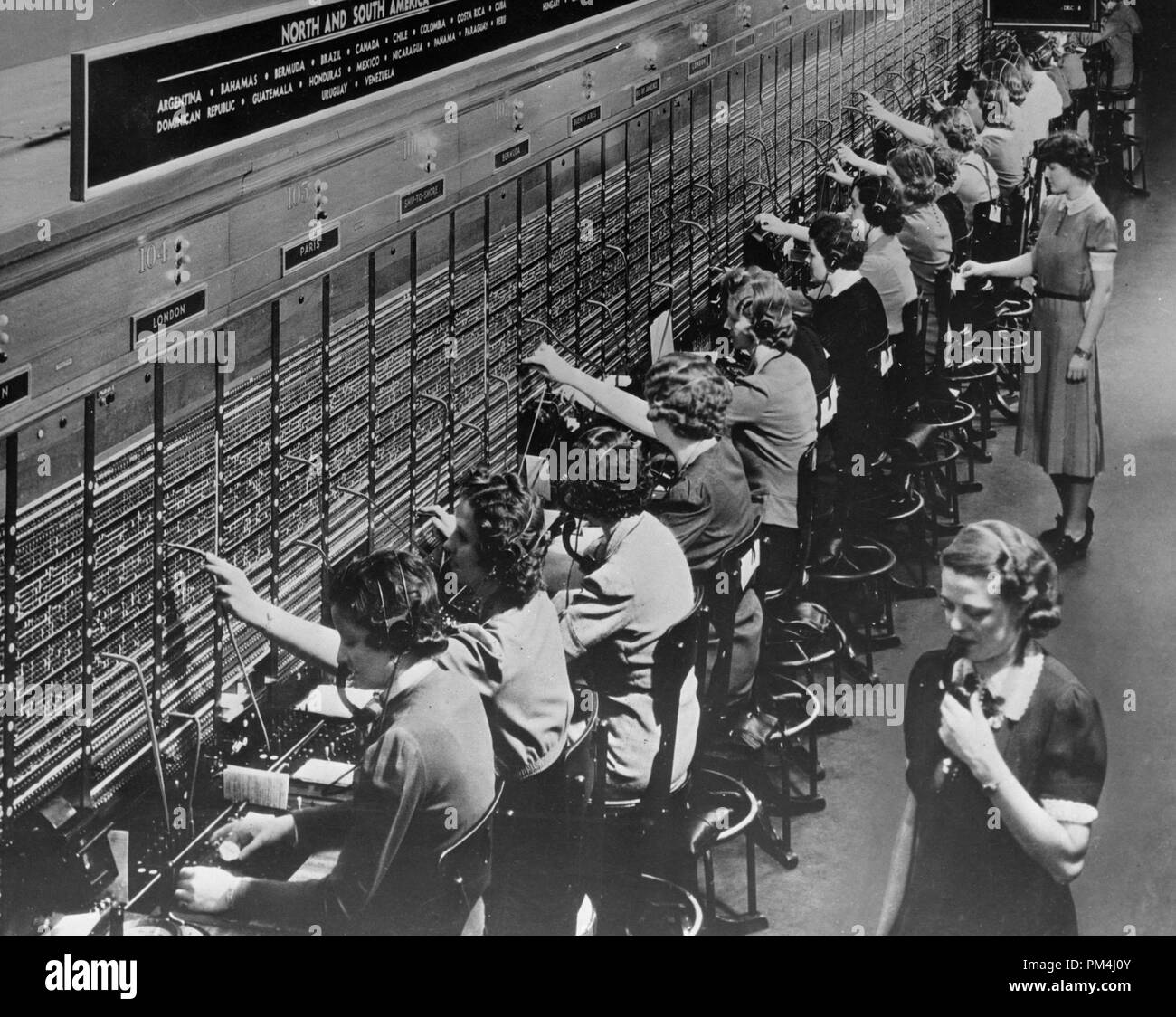 A Bell System switchboard where overseas calls are handled. Not all of the services shown are available during wartime conditions. December 22,1943   File Reference # 1003 459THA Stock Photo