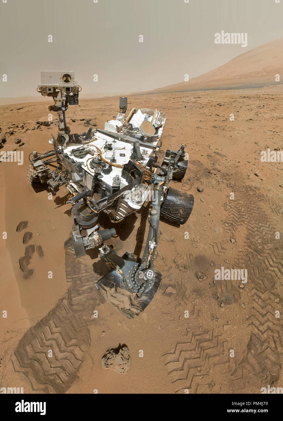 On Sol 84 (Oct. 31, 2012), NASA's Curiosity rover used the Mars Hand Lens Imager (MAHLI) to capture this set of 55 high-resolution images, which were stitched together to create this full-color self-portrait. The mosaic shows the rover at 'Rocknest,' the spot in Gale Crater where the mission's first scoop sampling took place. Four scoop scars can be seen in the regolith in front of the rover. The base of Gale Crater's 3-mile-high (5-kilometer) sedimentary mountain, Mount Sharp, rises on the right side of the frame. Mountains in the background to the left are the northern wall of Gale Crater. Stock Photo