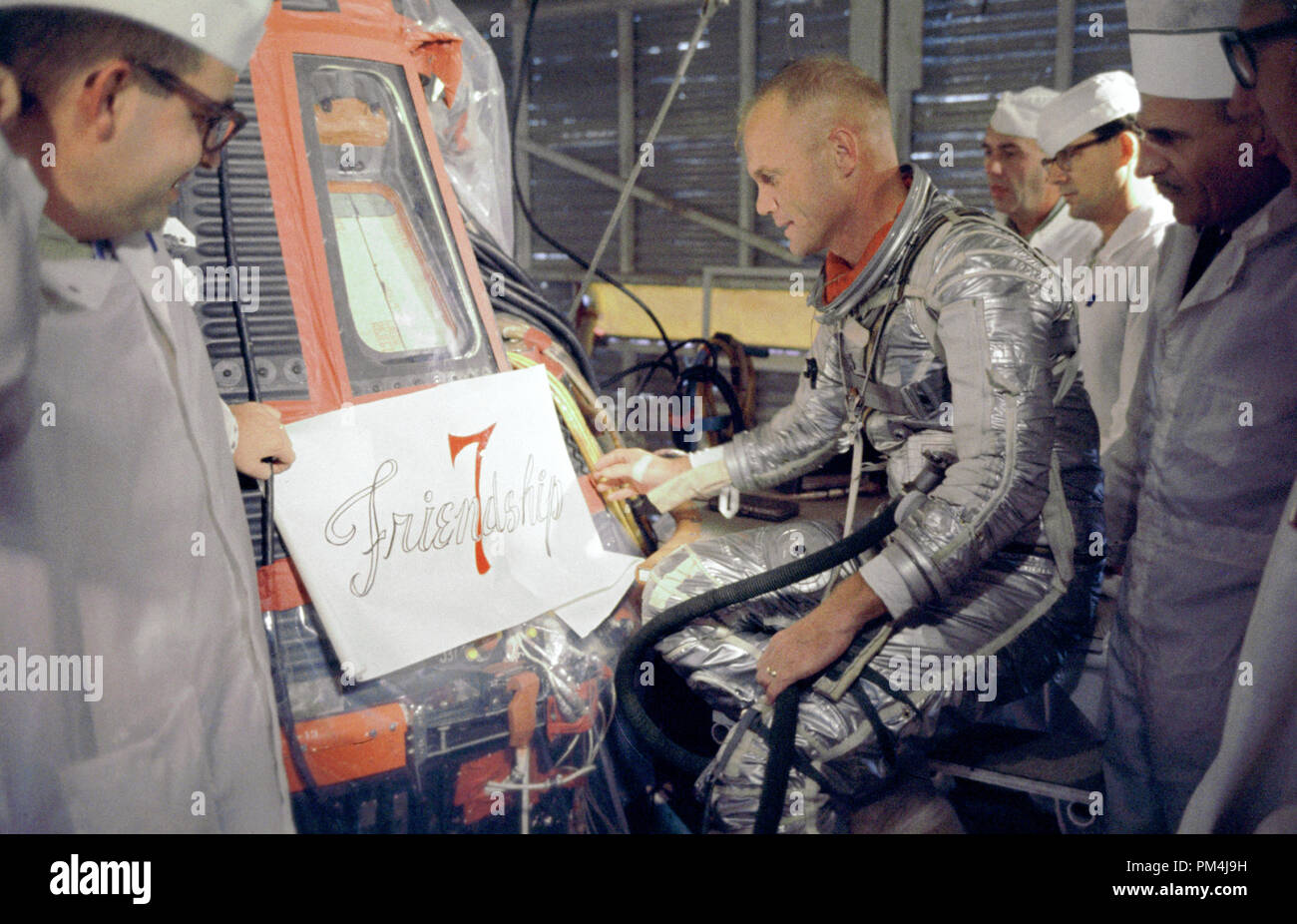 Astronaut John Glenn inspects artwork that will be painted on the outside of his Mercury spacecraft, which he nicknamed Friendship 7. On Feb. 20, 1962, Glenn lifted off into space aboard his Mercury Atlas (MA-6) rocket to become the first American to orbit the Earth. After orbiting the Earth 3 times, Friendship 7 landed in the Atlantic Ocean, just East of Grand Turk Island in the Bahamas. Glenn and his capsule were recovered by the Navy Destroyer Noa, 21 minutes after splashdown  File Reference # 1003 623THA Stock Photo