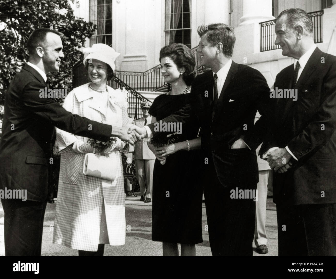 Commander Alan Shepard, first American in space, shakes hands with President John F. Kennedy. Also present are Mrs. Shepard, Jacqueline Bouvier Kennedy and Vice-President Lyndon B. Johnson, May 9, 1961   File Reference # 1003 642THA Stock Photo