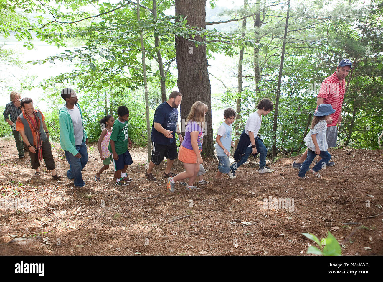 Lenny (Adam Sandler) walks through the woods with his daughter Becky (Alexys Nicole Sanger), sons Greg (Jake Goldberg) and Keithie (Cameron Boyce), Donna Lamonsoff (Ada-Nicole Sanger), Bean Lamonsoff (Frank Gingerich), Eric Lamonsoff (Kevin James), Andre McKenzie (Nadji Jeter), Kurt (Chris Rock), Charlotte (China Anne McClain), Rob (Rob Schneider) and Marcus Higgins (David Spade) towards the rope swing in Columbia Pictures' GROWN UPS. Stock Photo