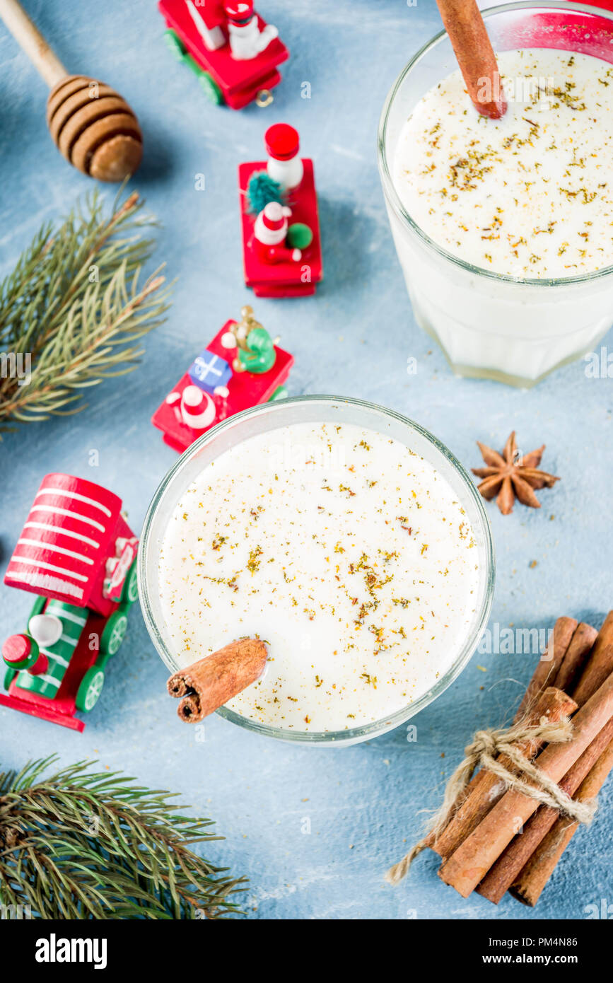 Traditional winter festive drink, sweet and spicy christmas eggnog cocktail in a glasses, on light blue background with xmas decorations, copy space t Stock Photo