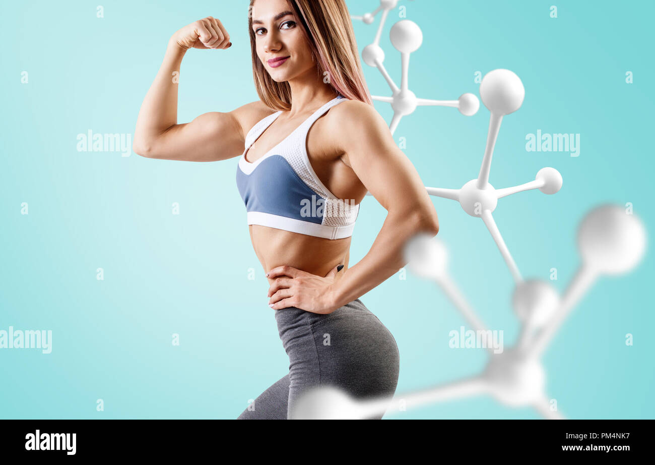 Athletic fitness woman standing near white molecule chain. Stock Photo