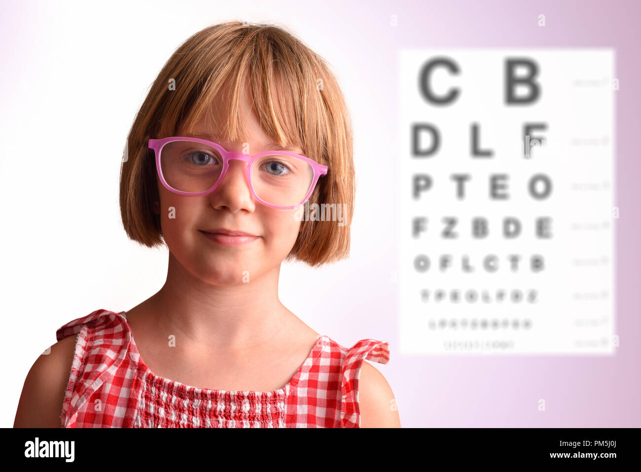 Child eye check with girl with glasses and letter board in the background. Concept of eye revision. Horizontal composition Stock Photo