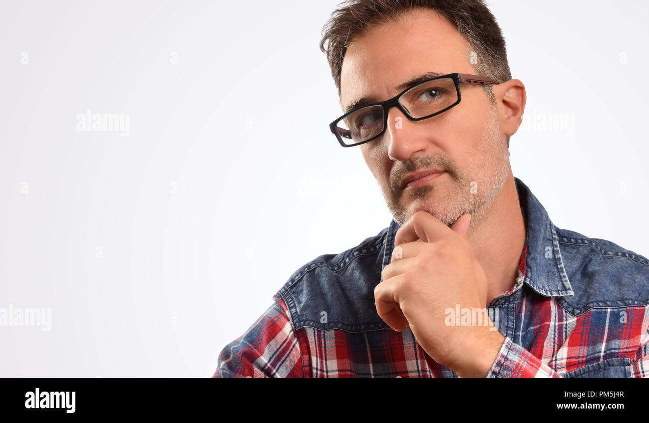 Modern man thoughtful checkered shirt and glasses. Portrait for concept of visual correction with glasses. Horizontal composition Stock Photo